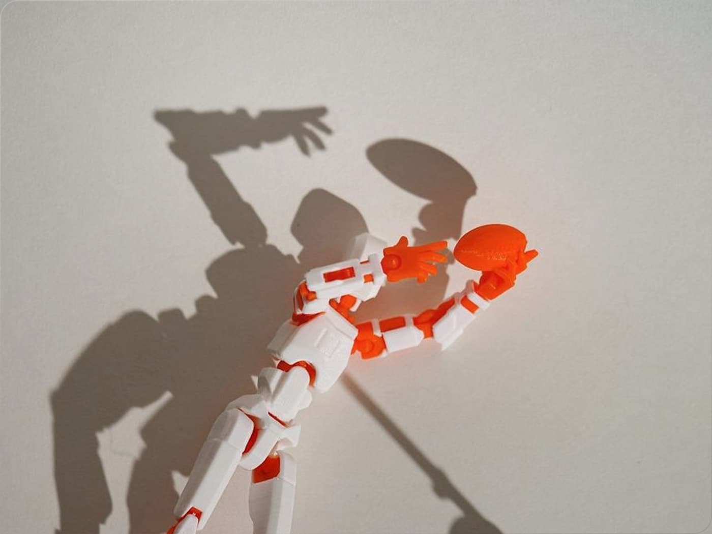 Orange and white Dummy 13 figure posed with a flying disc